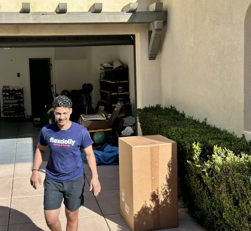Flexdolly mover carrying a box out of a client’s garage