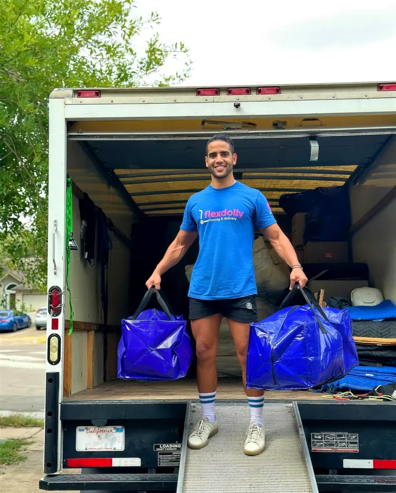 Flexdolly mover on the truck ramp carrying two blue moving bags
